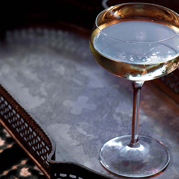 Glass of bubbly viewed from above on a copper serving tray.